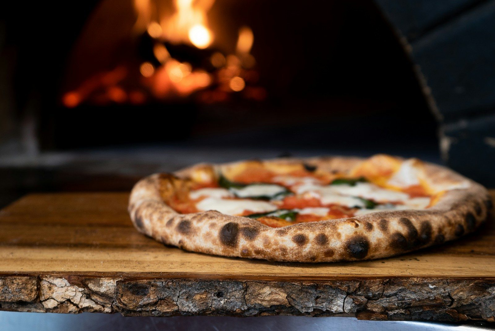 Margherita pizza with basil on a wooden board